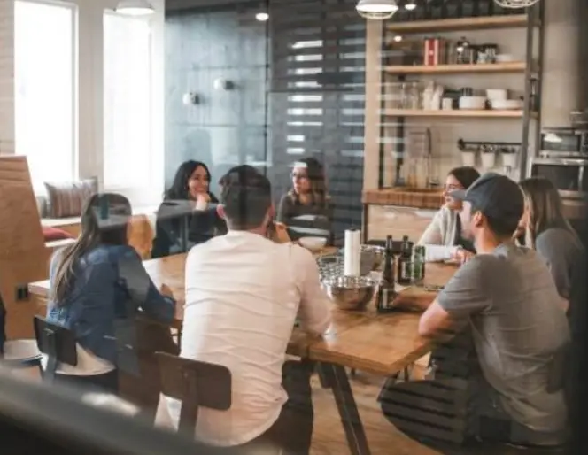 Quatre professionnels réunis autour d'une table pour une réunion d'affaires.